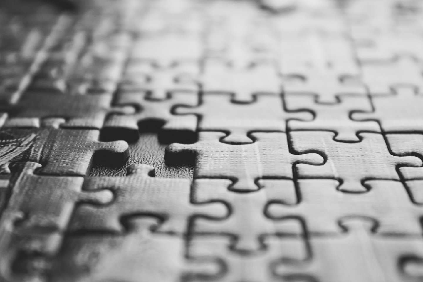 Close-up of interlocking jigsaw puzzle pieces, one missing from the pattern